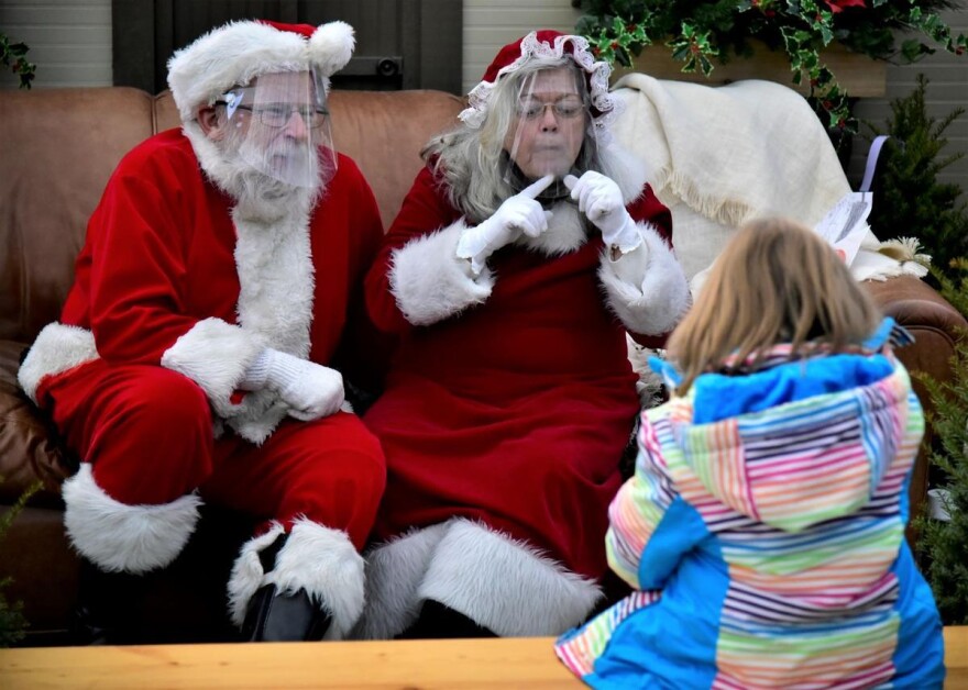 Santa and Mrs. Claus speak with a child at a garden store in Elkhart.