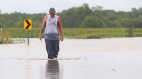Jordan King of Nashville wades through water on U.S. 45 in Graves County on July 19 determine how deep the water is and whether her car would be able to make it through it. Ultimately, King decided to turn around and try an alternate route.