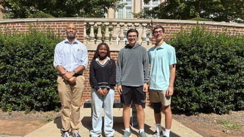 Civic Literacy Teacher Cristofer Wiley (left) stands with Reynolds High School students Tandy Adjei, Grant Cameron and Patrick Rais-Bahrami 