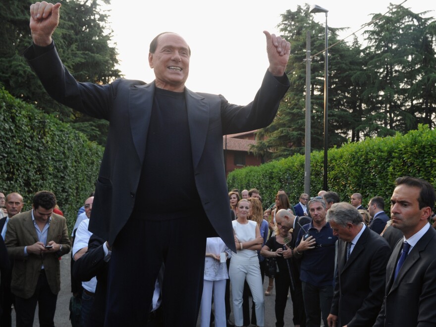 Former Italian Prime Minister Silvio Berlusconi hails his supporters in front of his house, Villa San Martino, on July 1 in Milan.