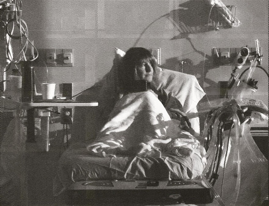 A woman in a hospital bed gazes to her left.