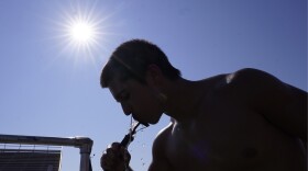 High school senior Areion Coln drinks water after football practice in Richardson, Texas, Monday, July 24, 2023. (AP Photo/LM Otero)