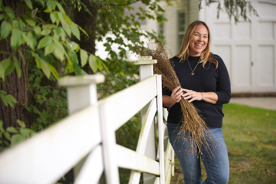 Elizabeth Sheeler, founder and creative director of Broadlawn Farm in Gates Mills, stands for a photo while holding some dried flax.