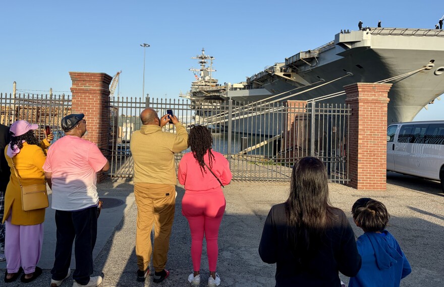 Families wait along the pier for the aircraft carrier USS George H.W. Bush to depart Norfolk.