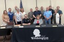 Washington City Council members, several city staff members and City Attorney Mark Walton gather behind new Washington Police Chief Jeff Stevens and Mayor Lilija Stevens after the council voted unanimously Monday to approve Jeff Stevens' contract.