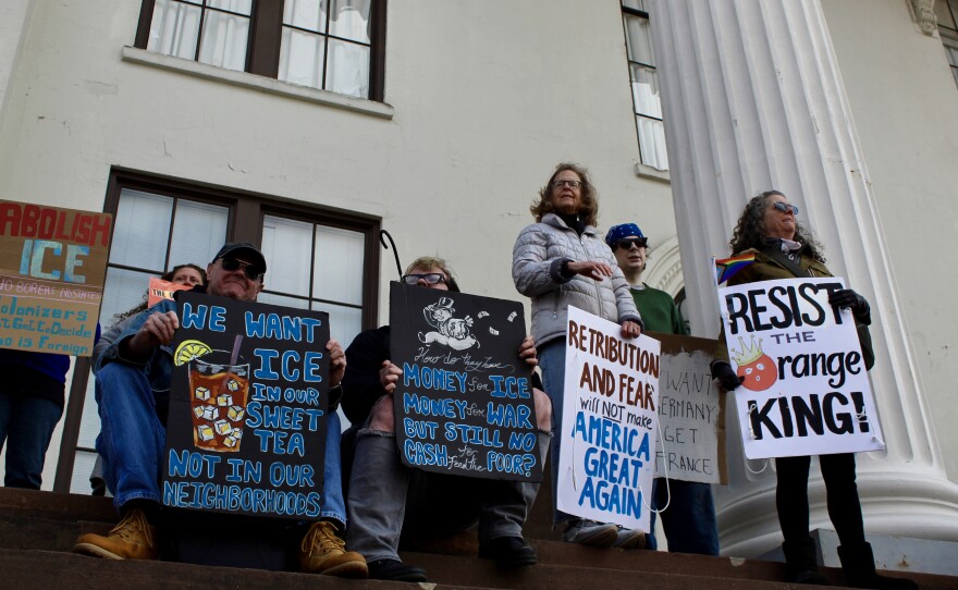 Four protestors at the top of the steps in front of Thalian Hall during the No Kings protest.