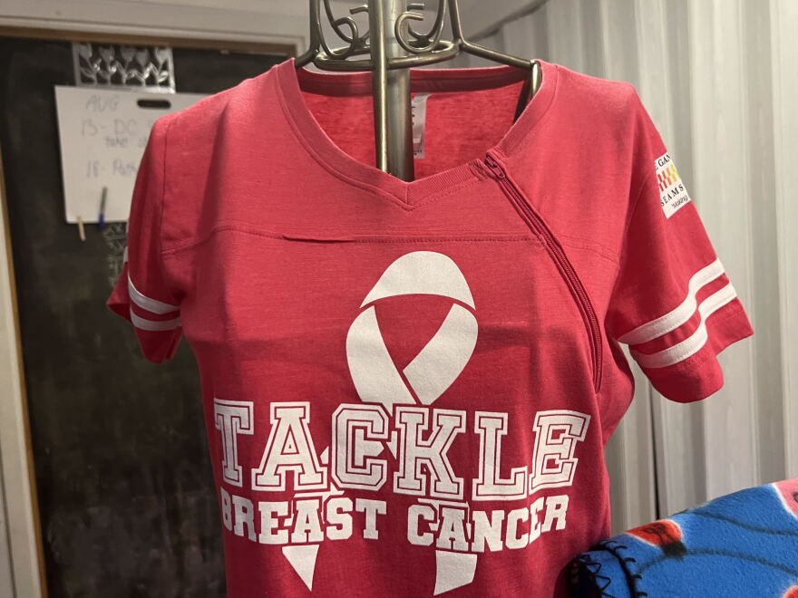 A zipper crosses the chest of a T-shirt. The design is more functional for chemotherapy treatments.