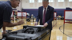 Republican gubernatorial candidate businessman Chris Doughty, right, casts his ballot, as election worker Todd Duffy, left, looks on, Tuesday, Sept. 6, 2022, in Wrentham, Mass., in the state's primary election. Doughty, a political newcomer, is going up against Republican Geoff Diehl who has former President Donald Trump's endorsement. 