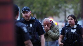 An unidentified man is led into the scene by police after they responded to a shooting at Seattle Center during the Bite of Seattle food festival Sunday, July 26, 2026, in Seattle, Wash. 