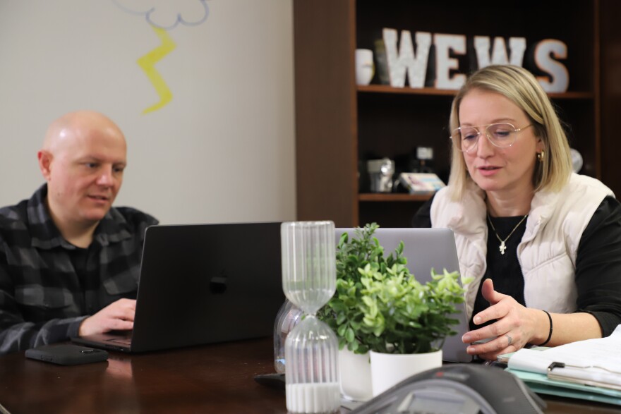 WEWS New5 News Director Jodie Heisner, left, and Digital Director Joe Donatelli work together at a table in Heisner's office at the TV station's studios in Cleveland, Ohio. Donatelli said he uses an AI agent created by News5's parent, E.W. Scripps, to catch and correct grammatical and website style errors.