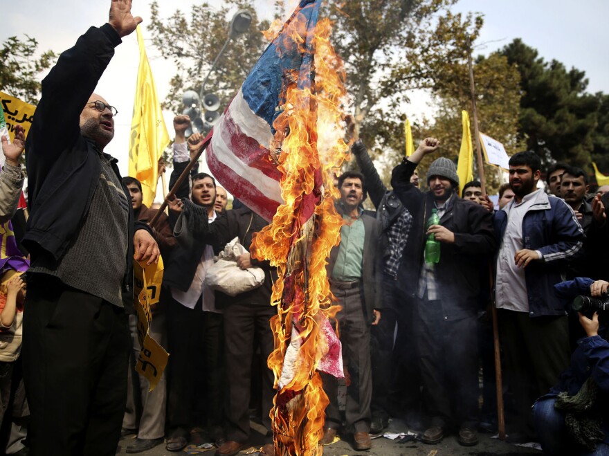 Iranian protesters burn an American flag during an annual anti-American rally in Tehran on Nov. 4, 2013. Tens of thousands of demonstrators packed the streets outside the former U.S. Embassy there in the biggest anti-American rally in years, a show of support for hard-line opponents of Rouhani's historic outreach to Washington.