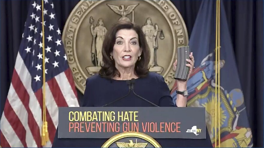 In this image taken from video, New York Gov. Kathy Hochul shows an extended rifle magazine during a news conference, Wednesday, May 18, 2022, in New York. New York would require state police to seek court orders to keep guns away from people who might pose a threat to themselves or others under a package of executive orders and gun control bills touted Wednesday by Hochul in the aftermath of a racist attack on a Buffalo supermarket.