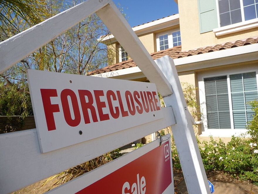 A picture of a foreclosure sign in front of a house.