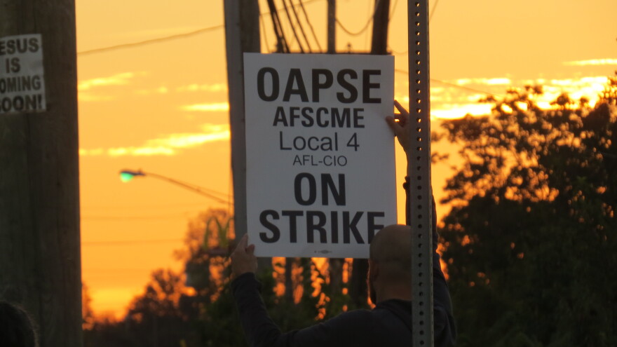 A Princeton bus driver holds an "On Strike" sign outside of First Student's bus garage in Sharonville.