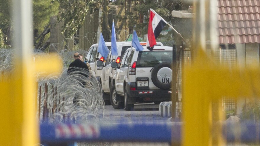 U.N. peacekeepers cross a checkpoint in the Golan Heights on Friday. Syrian rebels seized 21 peacekeepers from the Philippines and are insisting that Syrian troops leave the area.