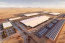 Digital rendering of a data center campus in the desert. There are several huge buildings and rows of smaller buildings and infrastructure.