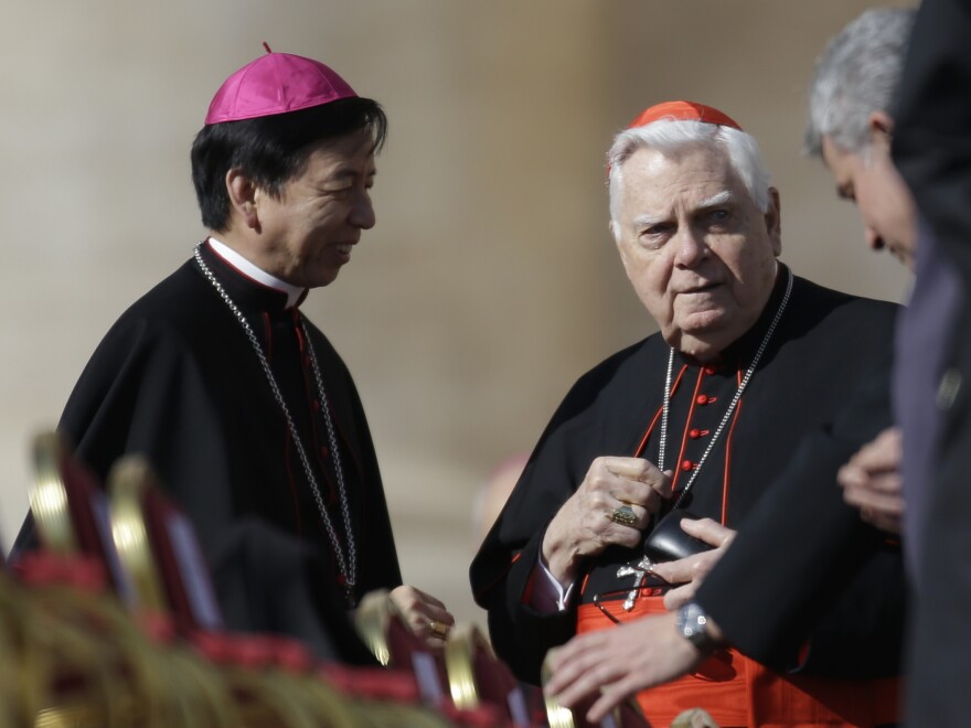 Cardinal Bernard Law (right) speaks with unidentified prelates as he attends Pope Benedict XVI's last general audience in St. Peter's Square at the Vatican in 2013.