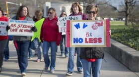 Elizabeth Ferguson Hollifield, a teacher from Princeton W.Va., holds a sign as she walks to a teacher rally Monday, March 5, 2018.