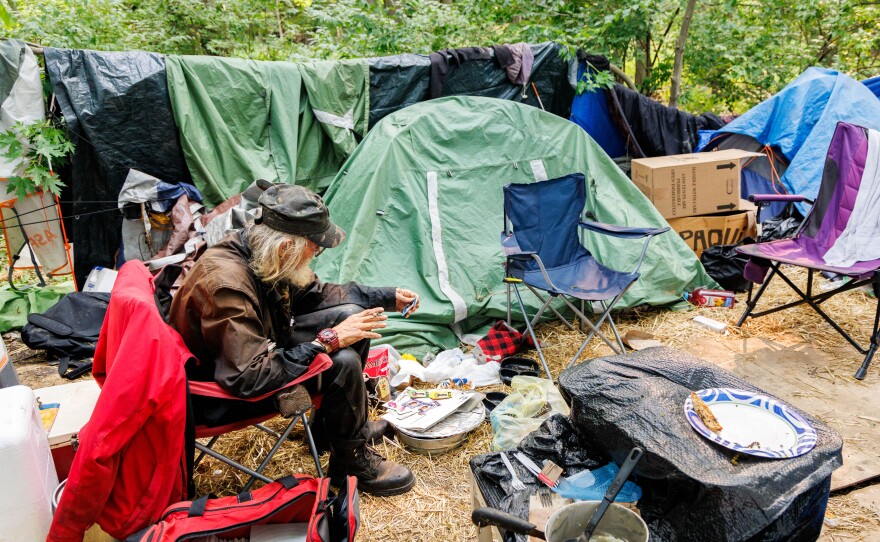 Louis Ray Starr in his crowded tent encampment.