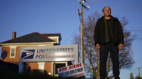 Gerald Groff, a former postal worker whose case will be argued before the Supreme Court, stands during a television interview near a "Now Hiring" sign posted at the roadside at the United State Postal Service, Wednesday, March 8, 2023, in Quarryville, Pa.