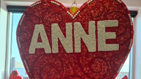 A large heart in a window with small hearts at the bottom of the window. 