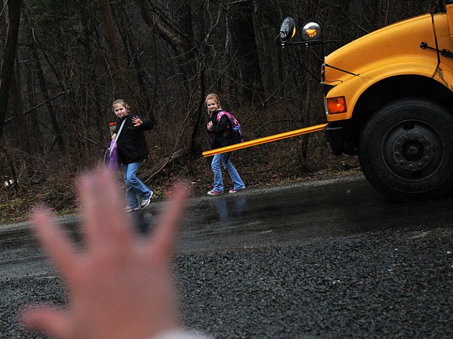 Kristy Stumpf, who works from her home in Broad Run, Va., part of the week, greets her daughters Lauren, 9 (left), and Lacey, 6 (right), as they hop off the school bus. Stumpf's employer, List Innovative Solutions, lets employees largely set their own hours.