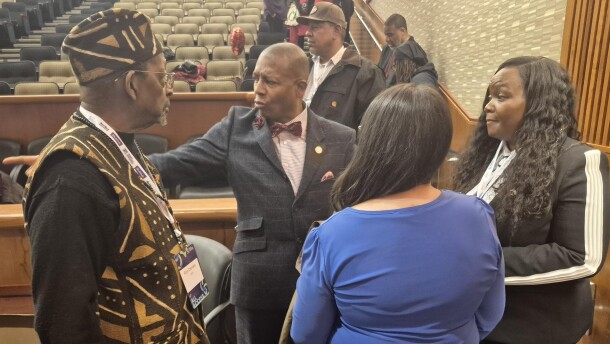 Sen. James Sanders, D-Queens, (center) and commission chairperson Seanelle Hawkins (right) huddle after a discussion on reparations during Caucus Weekend.