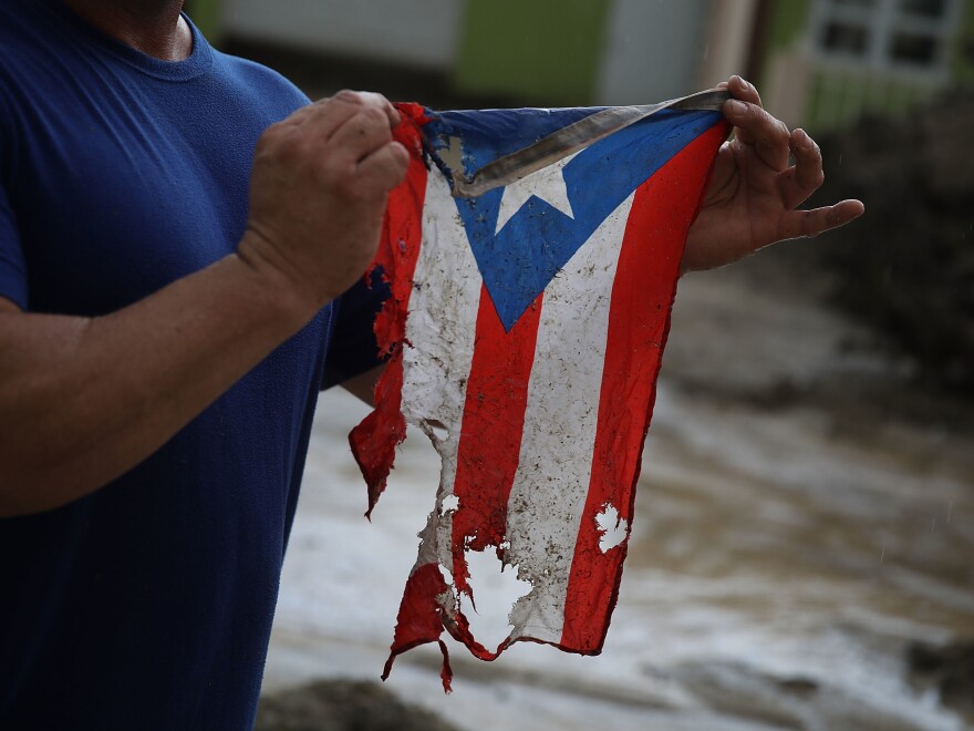 Jose Javier Santana says this torn and frayed Puerto Rican flag is representative of the state of the island now — eight months after Hurricane Maria hit.