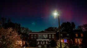 The aurora borealis glows over St. Louis’ Shaw neighborhood in this long exposure photograph during the waning hours of Tuesday, Nov. 11, 2025, in St. Louis, Missouri.