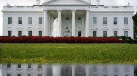 The White House is seen reflected in a puddle, Saturday, Sept. 3, 2022, in Washington. 