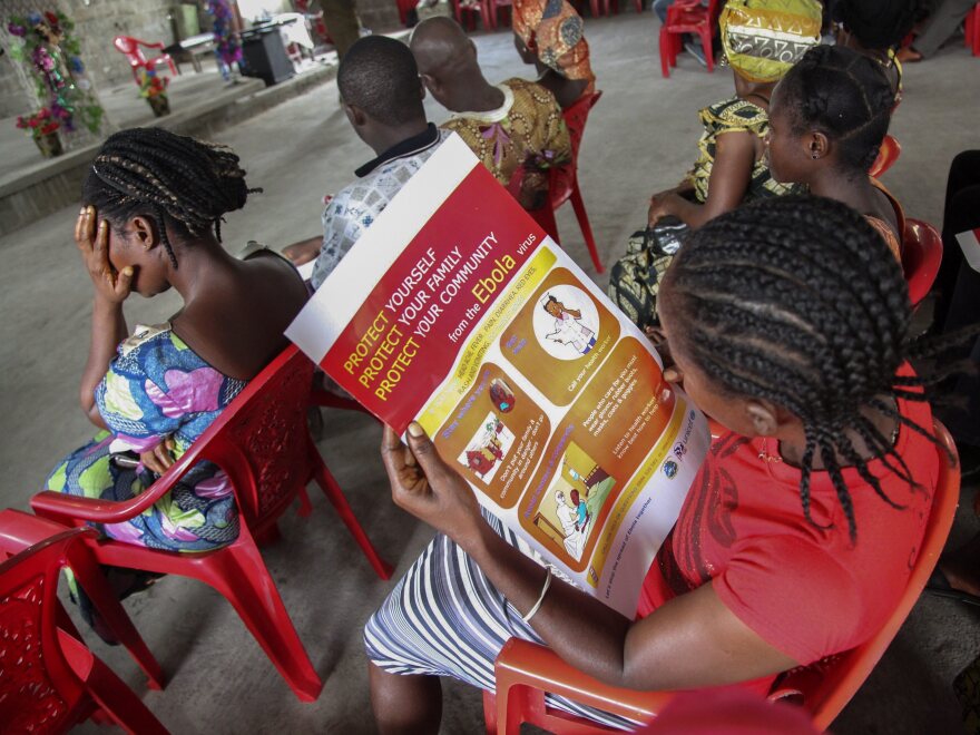 A woman reads a poster on the prevention of Ebola at a UNICEF event in Monrovia, Liberia, on June 22.