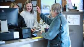 A customer waves to employees at Rockers Pharmacy after picking up a prescription. (Bek Shackelford-Nwanganga/Kansas News Service)