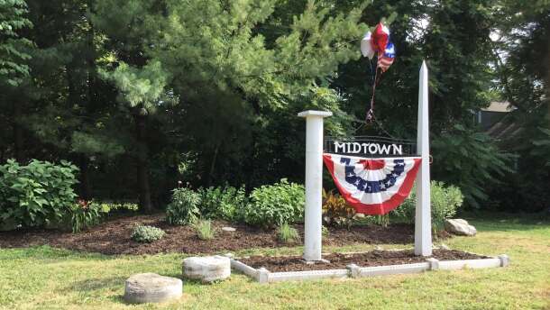 A Midtown Neighborhood sign is decorated for the 4th of July.