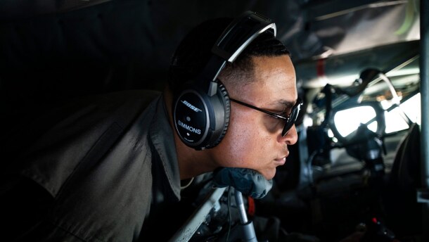 U.S. Air Force Tech. Sgt. Tyler Simmons in an airplane with headset and sunglasses on.