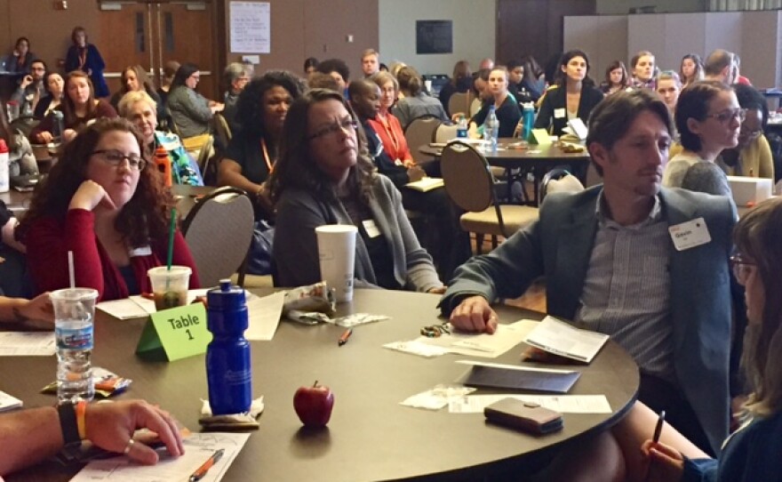 Room of of people sitting at round tables at Humanity Summit at Illinois Wesleayn University