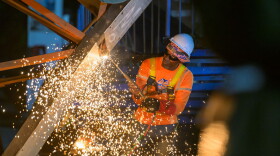 Pictured: A worker with DPW contractor, Rumina Construction, cuts through the steel framework of the former Addelita Cancryn Pedestrian Bridge on St. Thomas during demolition work Friday evening.