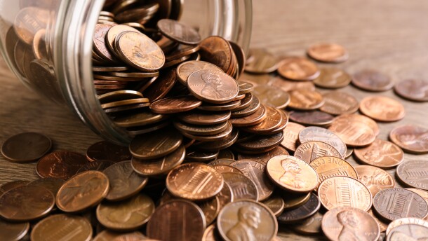 Glass jar with coins on table, closeup. Money saving concept
