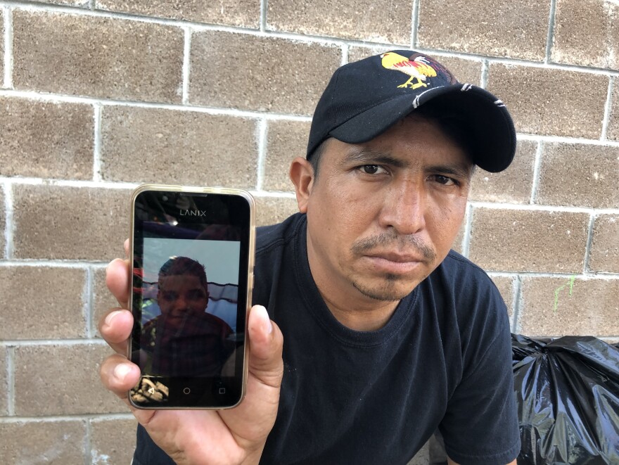Delmer Lopez holds his cellphone showing a picture of his son. Lopez has lost his asylum case, but decided to send 10-year-old Jose Armando across the bridge alone three weeks ago.