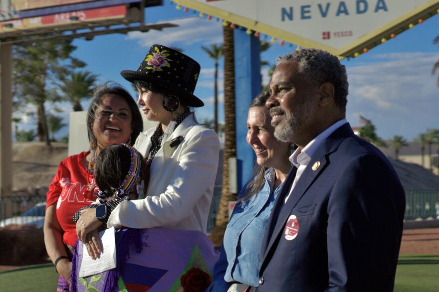 Tammi Tiger (left), Barbara Hartzell, Shea Backus, Steven Hoursford (right), stand in front of the Welcome to Las Vegas sign in honor of Indigenous Peoples Day on Oct. 12, 2026. (Jimmy Romo/KNPR)