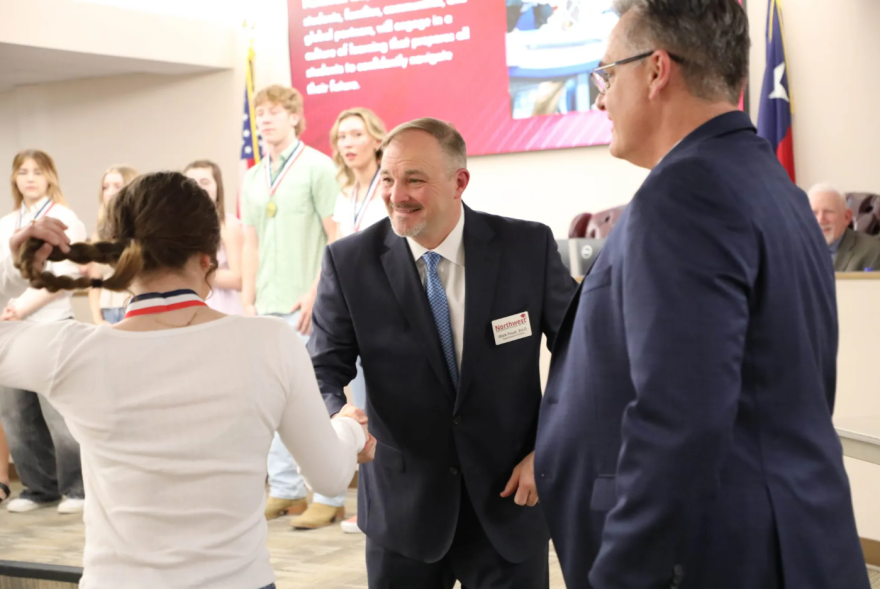 Northwest ISD Superintendent Mark Foust shakes a student’s hand during a school board meeting Feb. 26, 2024, at the district’s administration building in Justin.