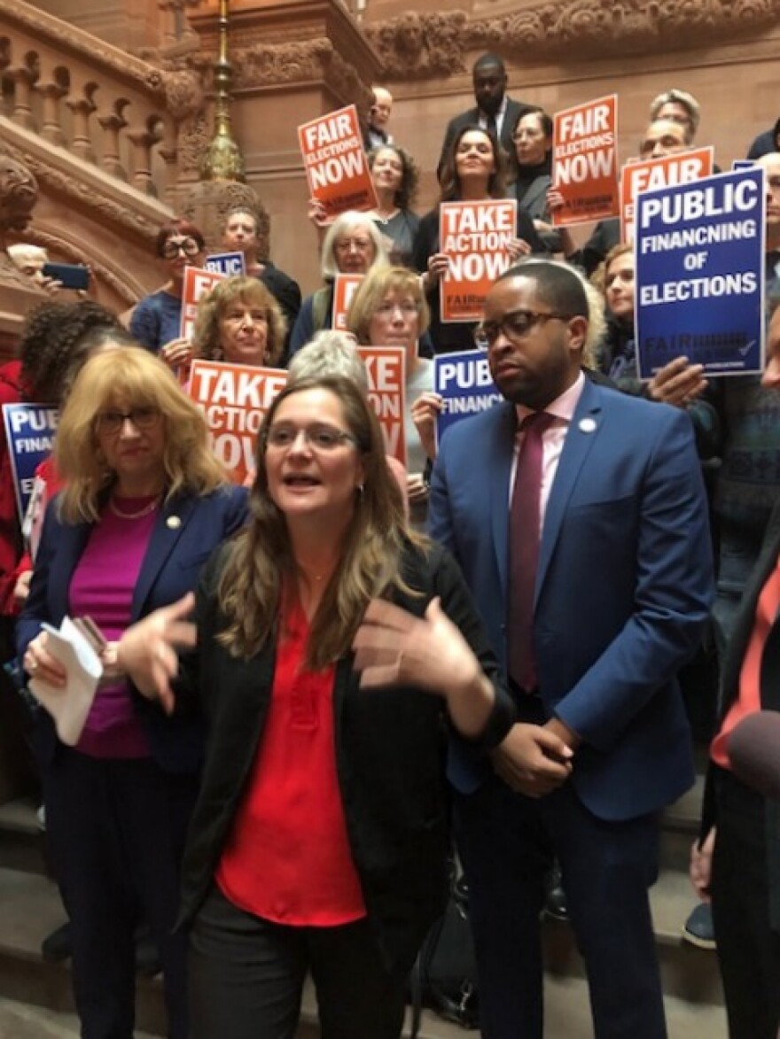 Jessica Wisneski, with Citizen Action, speaks at a pro public campaign fiance rally at the Captiol's million dollar staircase on Tuesday