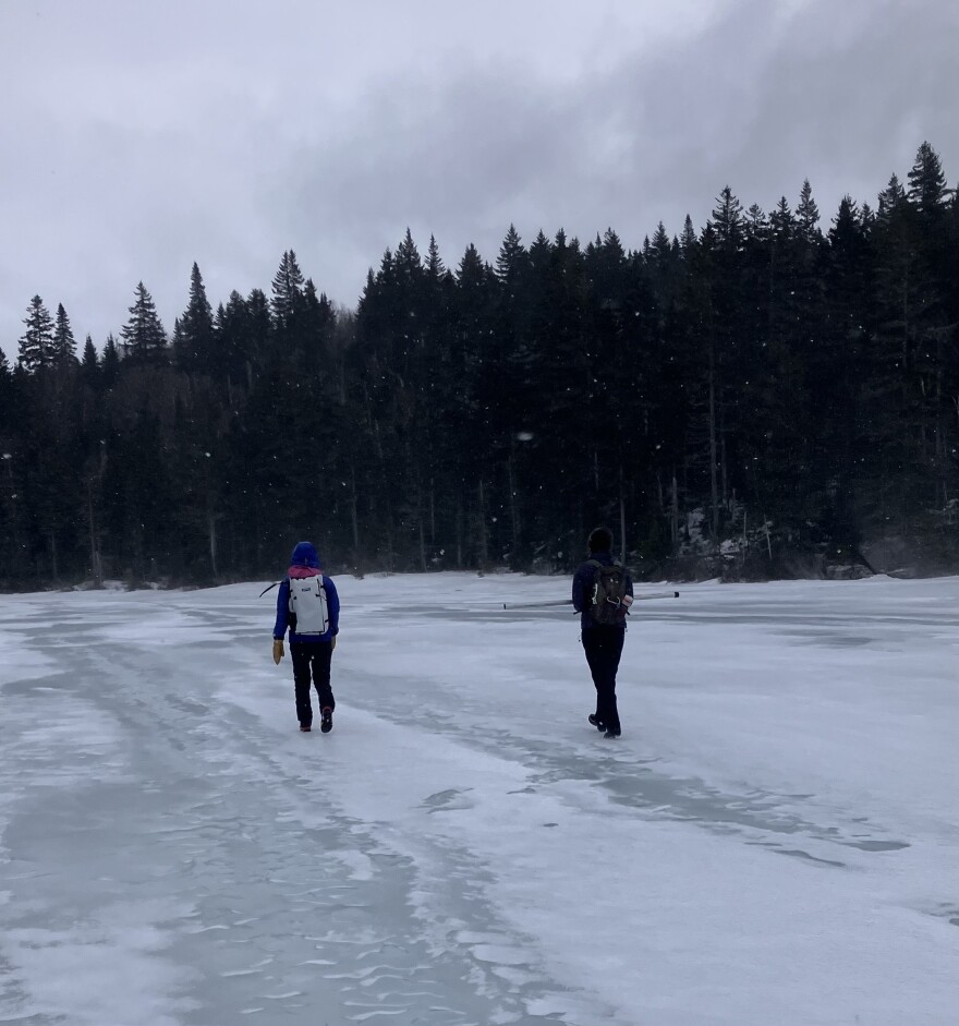 Researchers cross a frozen pond on Saddleback Mountain.