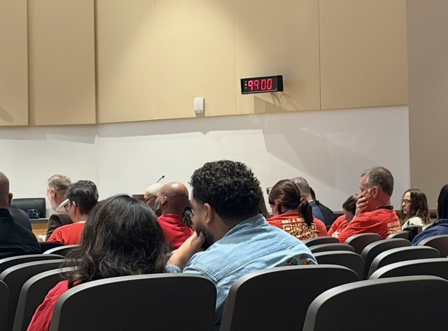 Union members and audience members react after the Orange County School Board voted to postpone a hearing over proposed employee health insurance changes until next month.