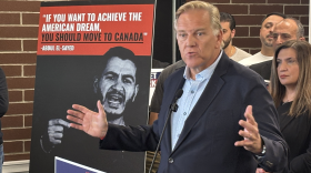 Republican U.S. Senate candidate Mike Rogers speaks at a lectern, gesturing with both hands.