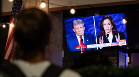 A viewer stops to watch a screen displaying the US Presidential debate between Vice President and Democratic presidential candidate Kamala Harris and former US President and Republican presidential candidate Donald Trump at The Admiral restaurant in Washington, DC.