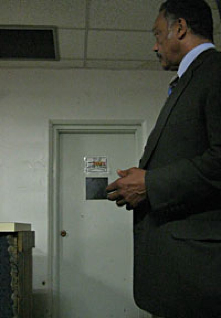 Rev. Jesse Jackson stands in front of the church basement door where Mark Anthony Barmore was fatally shot.