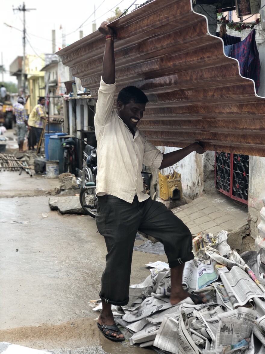 A man carries the woven, bamboo roofing material prototype created by Alexa Bednarz. Courtesy of Alexa Bednarz.