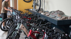 Jacob Douglas, co-owner of Lakeshore Bike in Marquette, moves an e-bike back into a selection of e-bikes at his shop.