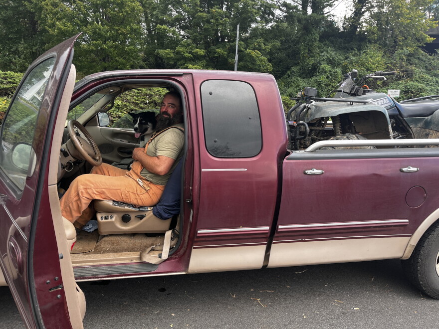 Swannanoa resident Robert Blount, with his dog Loretta, waiting in line for gas in Asheville on Sept. 28, 2024.