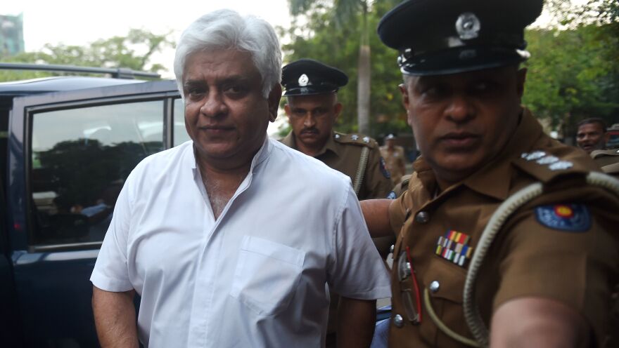 Police arrest Arjuna Ranatunga, Sri Lanka's petroleum minister and former cricket star, in Colombo on Monday. The arrest followed a confrontation in which his bodyguards opened fire on a group of protesters loyal to the president.